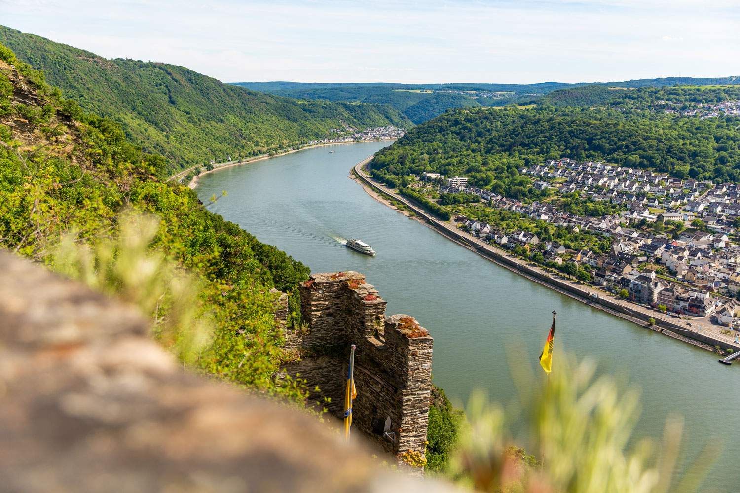 Blick auf den Rhein mit einem Schiff in der Mitte, rechts eine Stadt